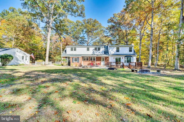 view of front of home with a deck and a front lawn