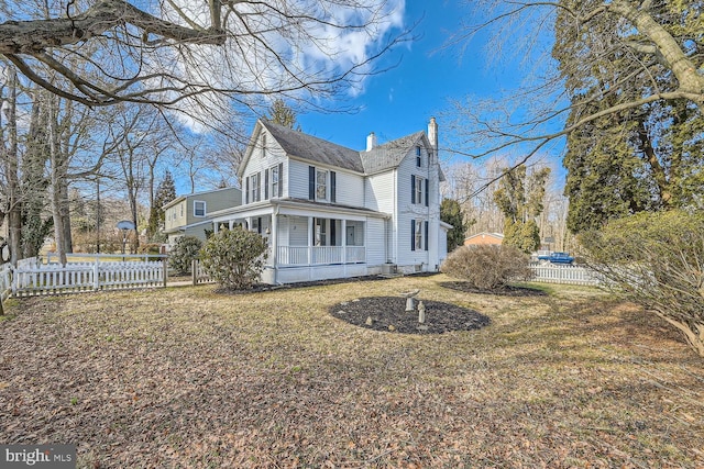 view of side of property with a sunroom, fence, a chimney, and a lawn