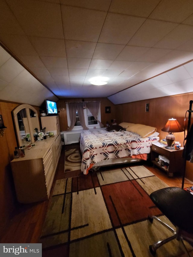 bedroom featuring hardwood / wood-style floors and vaulted ceiling