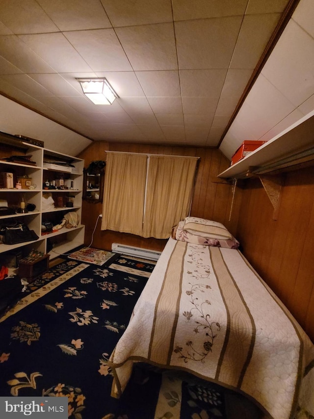 bedroom with baseboard heating, wooden walls, and vaulted ceiling