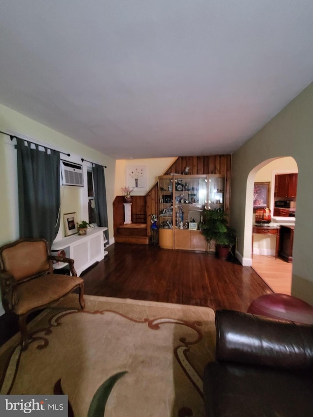 living room featuring an AC wall unit and hardwood / wood-style floors