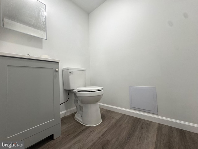 bathroom with toilet, lofted ceiling, vanity, and hardwood / wood-style floors