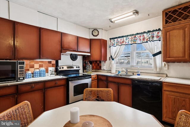 kitchen with decorative backsplash, black dishwasher, sink, and stainless steel range with electric cooktop