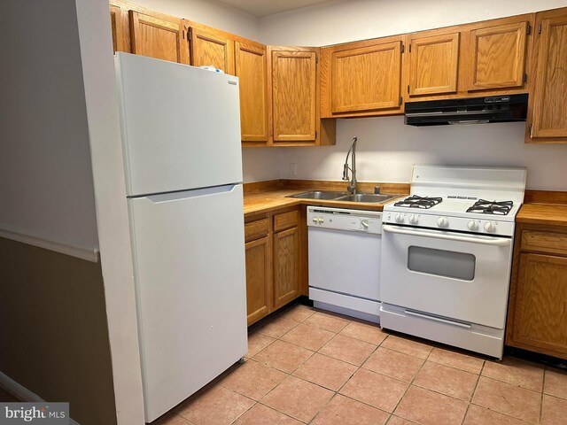 kitchen with sink, white appliances, and light tile patterned floors