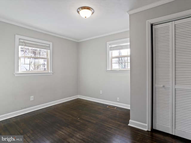 unfurnished bedroom featuring ornamental molding, a closet, and dark hardwood / wood-style flooring