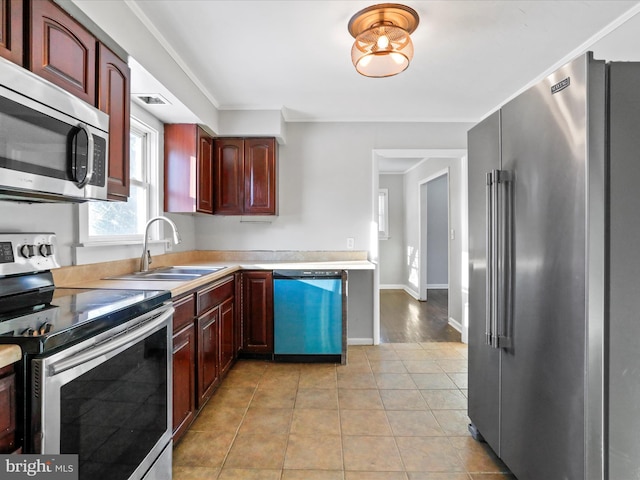 kitchen with sink, light tile patterned floors, and appliances with stainless steel finishes