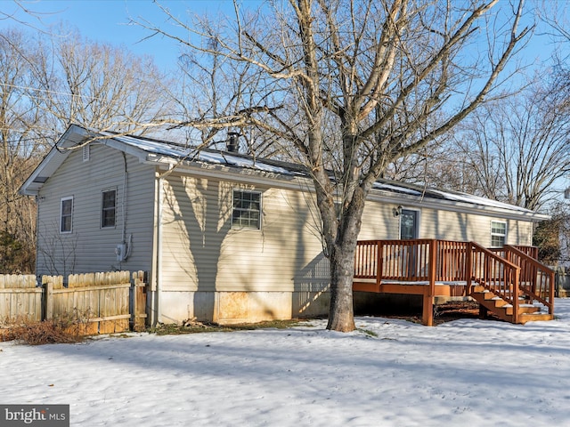 snow covered property with a wooden deck