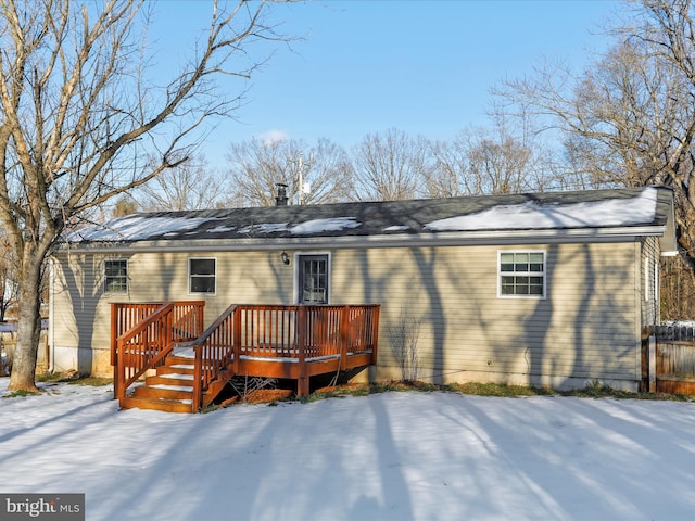 snow covered house with a deck