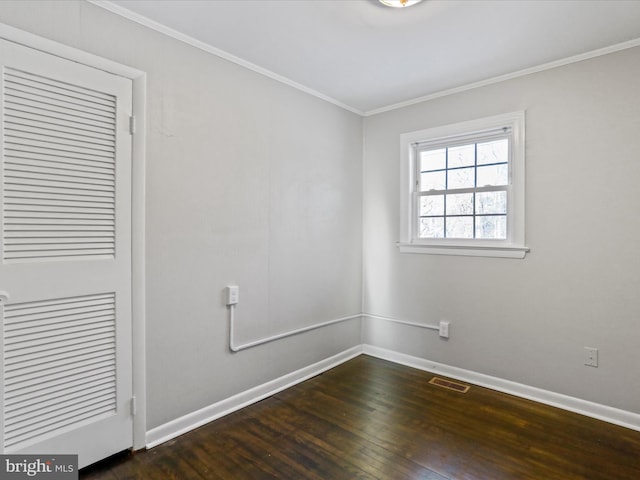 empty room with dark hardwood / wood-style flooring and ornamental molding