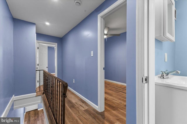 corridor with sink and dark wood-type flooring