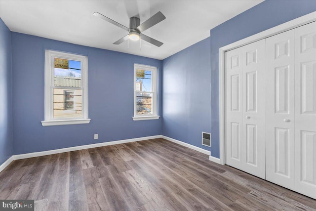 unfurnished bedroom with ceiling fan, hardwood / wood-style floors, and a closet