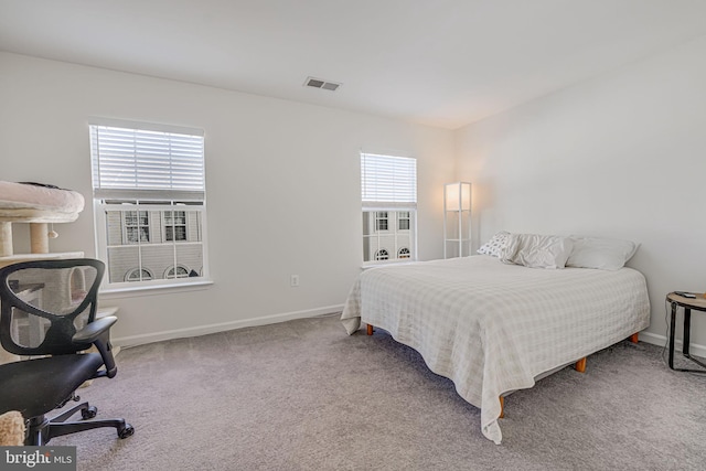 carpeted bedroom featuring multiple windows