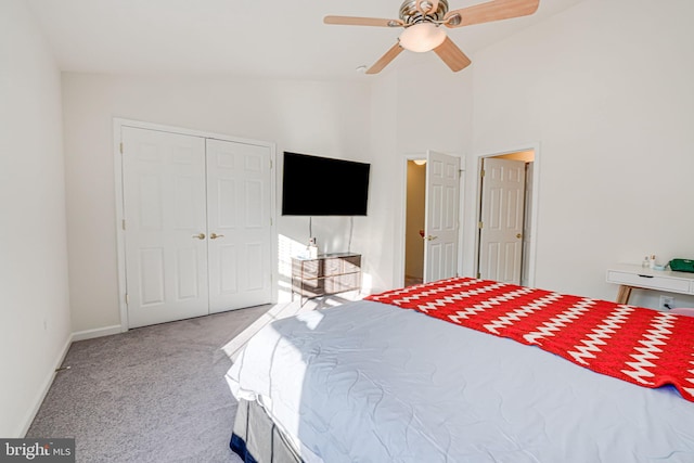 bedroom with vaulted ceiling, a closet, light carpet, and ceiling fan