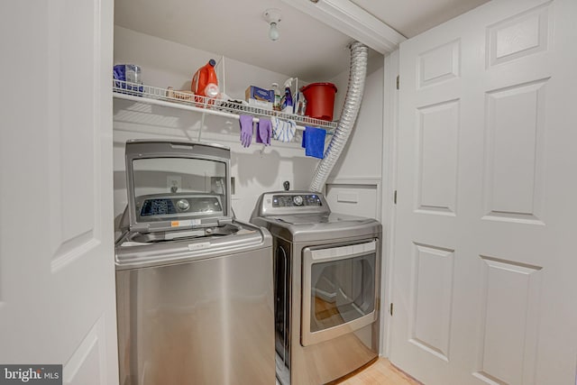 laundry room with washer and clothes dryer and hardwood / wood-style floors