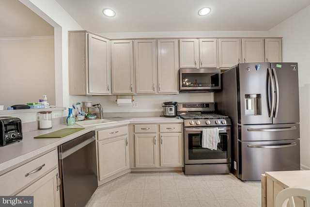 kitchen featuring sink, ornamental molding, and appliances with stainless steel finishes