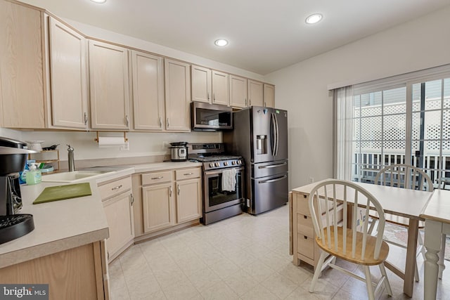 kitchen featuring stainless steel appliances, sink, and light brown cabinetry