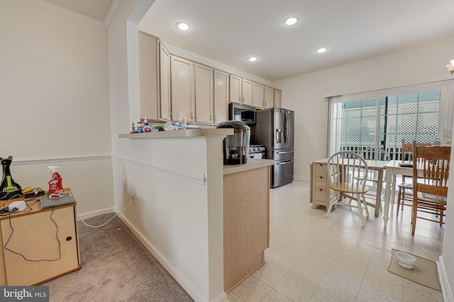 kitchen featuring kitchen peninsula, light brown cabinetry, appliances with stainless steel finishes, and ornamental molding