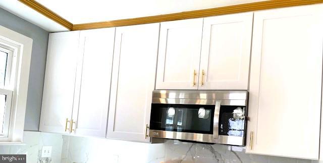 interior space featuring white cabinets and decorative backsplash