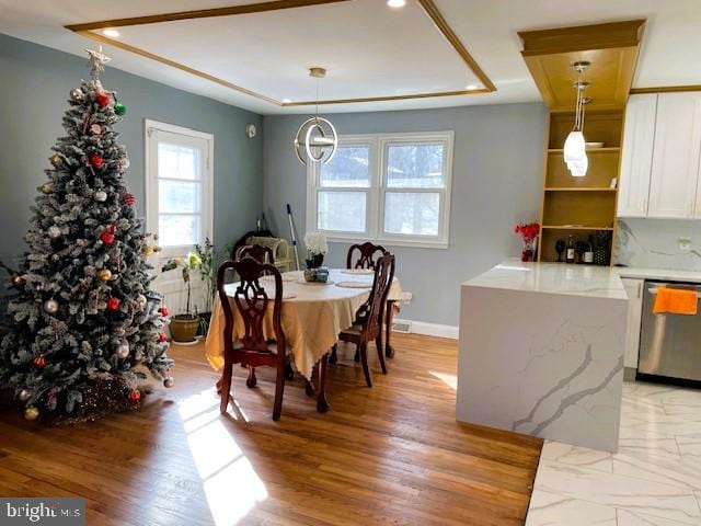 dining space with light wood-type flooring and a notable chandelier