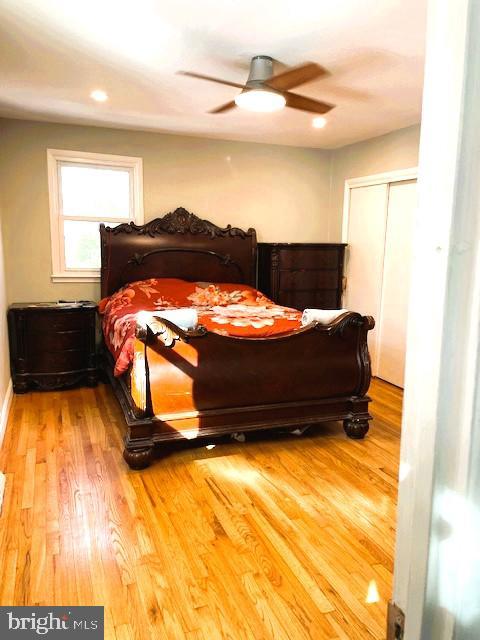 bedroom featuring ceiling fan, a closet, and hardwood / wood-style floors