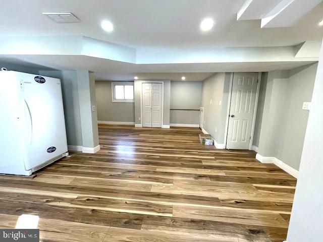 basement with white fridge and hardwood / wood-style floors