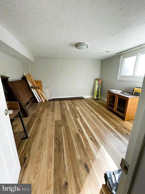 interior space featuring a textured ceiling and hardwood / wood-style flooring