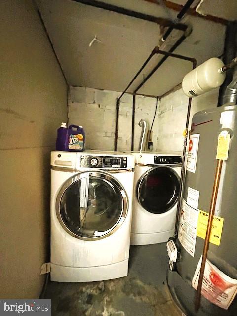 clothes washing area featuring washing machine and dryer and water heater