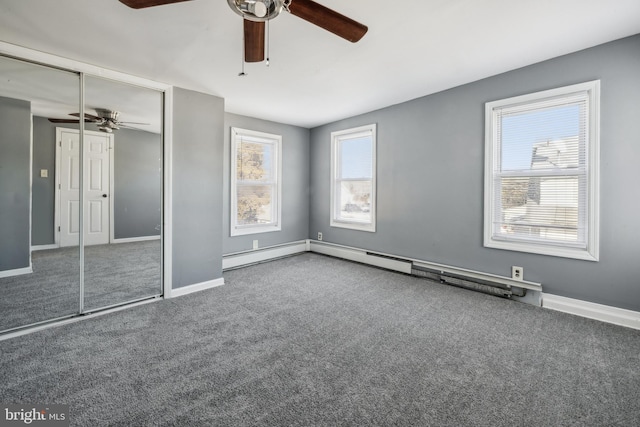 unfurnished bedroom with ceiling fan, carpet flooring, a baseboard radiator, and multiple windows