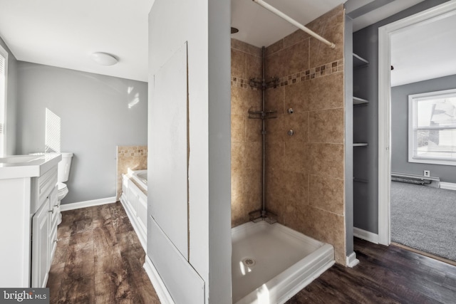 bathroom featuring toilet, a shower, hardwood / wood-style floors, and vanity