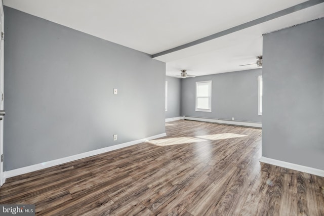 spare room featuring baseboard heating, hardwood / wood-style flooring, and ceiling fan