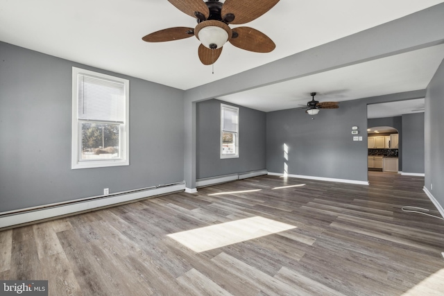 spare room with plenty of natural light, hardwood / wood-style floors, and a baseboard heating unit