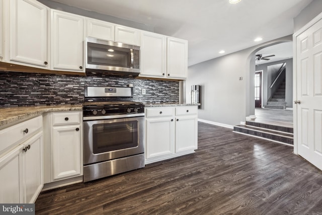 kitchen with dark hardwood / wood-style floors, stainless steel appliances, white cabinetry, and light stone counters