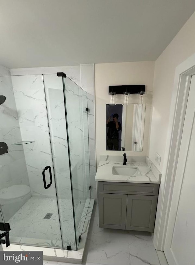 bathroom featuring toilet, an enclosed shower, and vanity