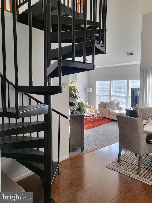 stairs featuring a high ceiling and hardwood / wood-style floors