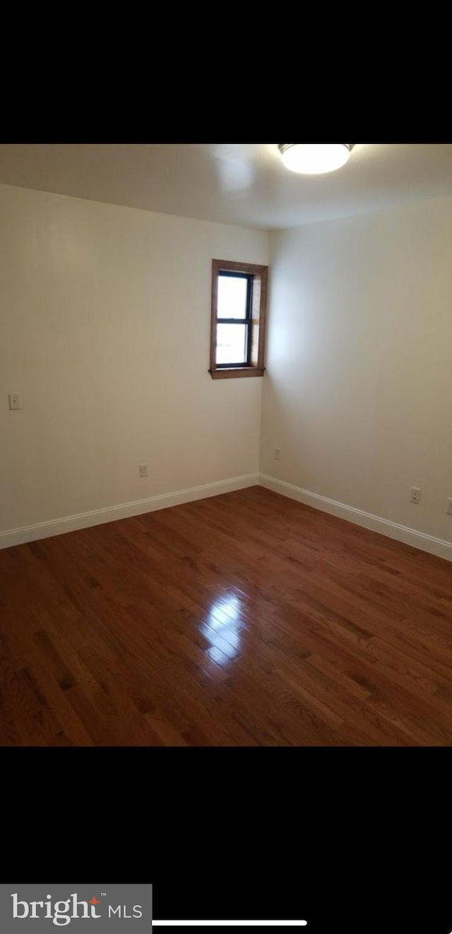 spare room with dark hardwood / wood-style floors