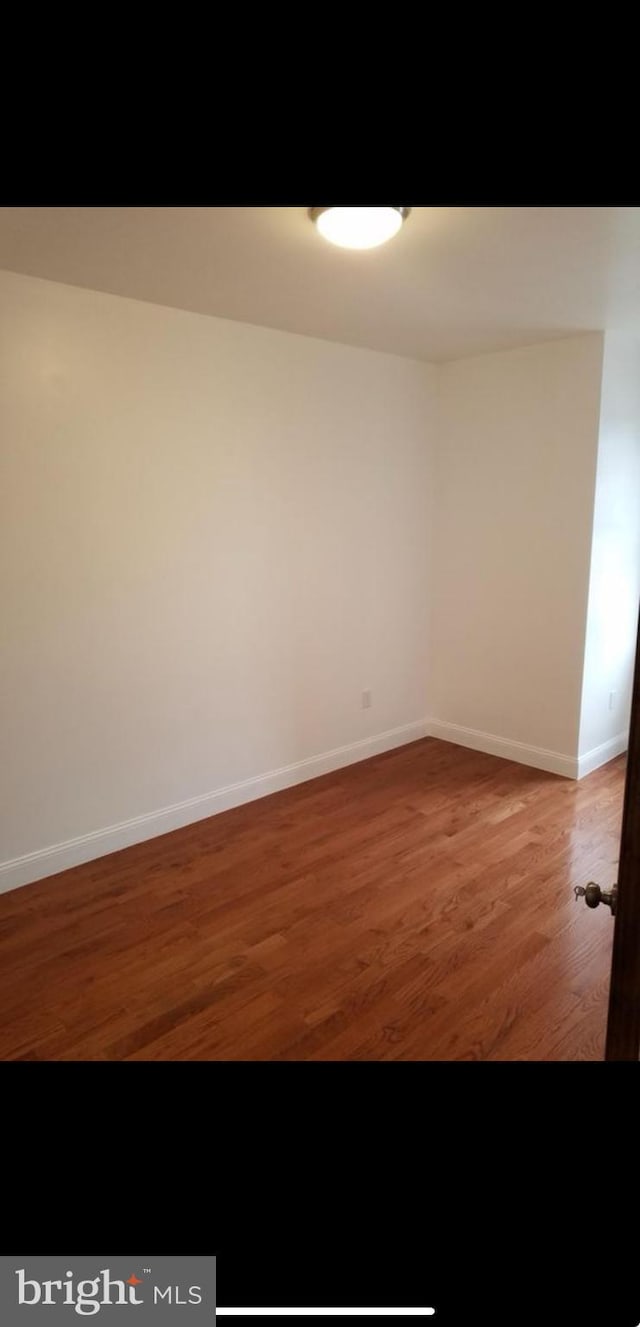 empty room with dark hardwood / wood-style flooring