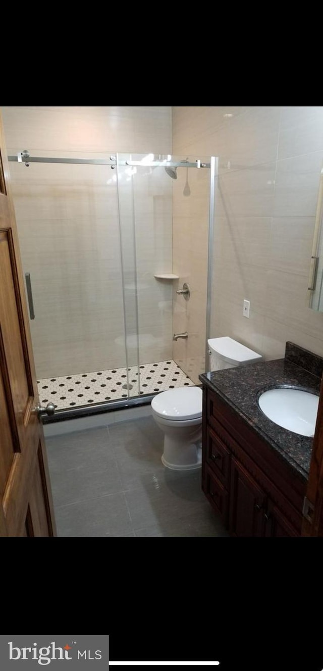 bathroom with vanity, an enclosed shower, tile patterned floors, and toilet