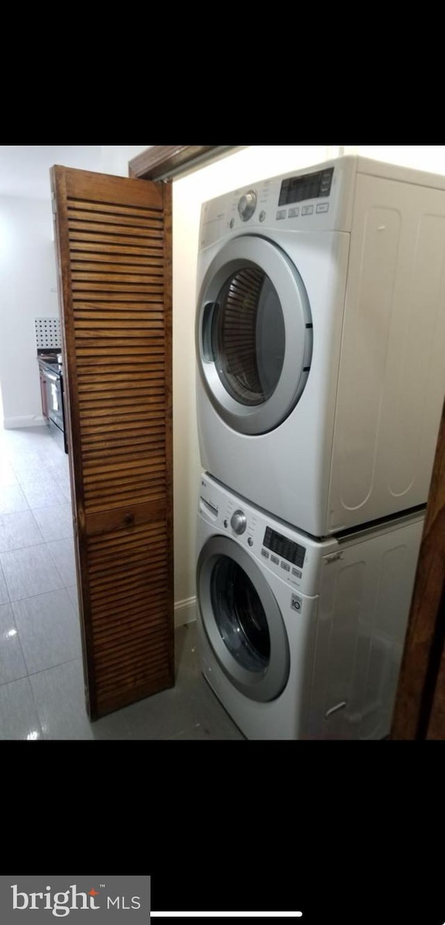 clothes washing area featuring stacked washer / drying machine