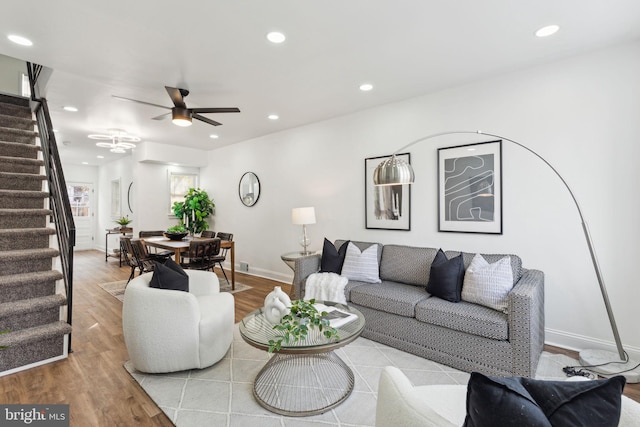 living room with ceiling fan and light hardwood / wood-style flooring