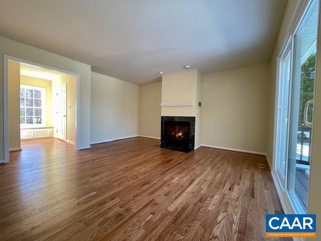 unfurnished living room featuring hardwood / wood-style flooring and a wealth of natural light