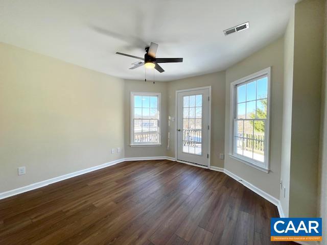 unfurnished room featuring dark wood-type flooring and ceiling fan