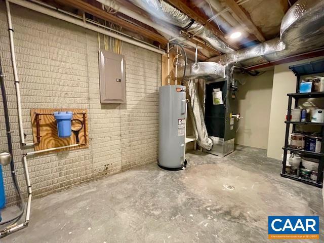 basement featuring heating unit, water heater, and electric panel