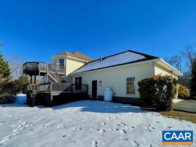 snow covered property featuring a deck