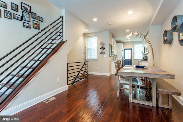 dining space with a notable chandelier and dark hardwood / wood-style flooring