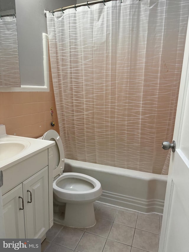 full bathroom featuring toilet, tile patterned flooring, tile walls, shower / tub combo, and vanity