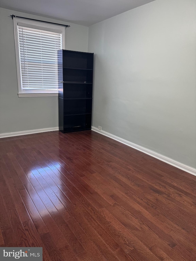 unfurnished room with dark hardwood / wood-style flooring