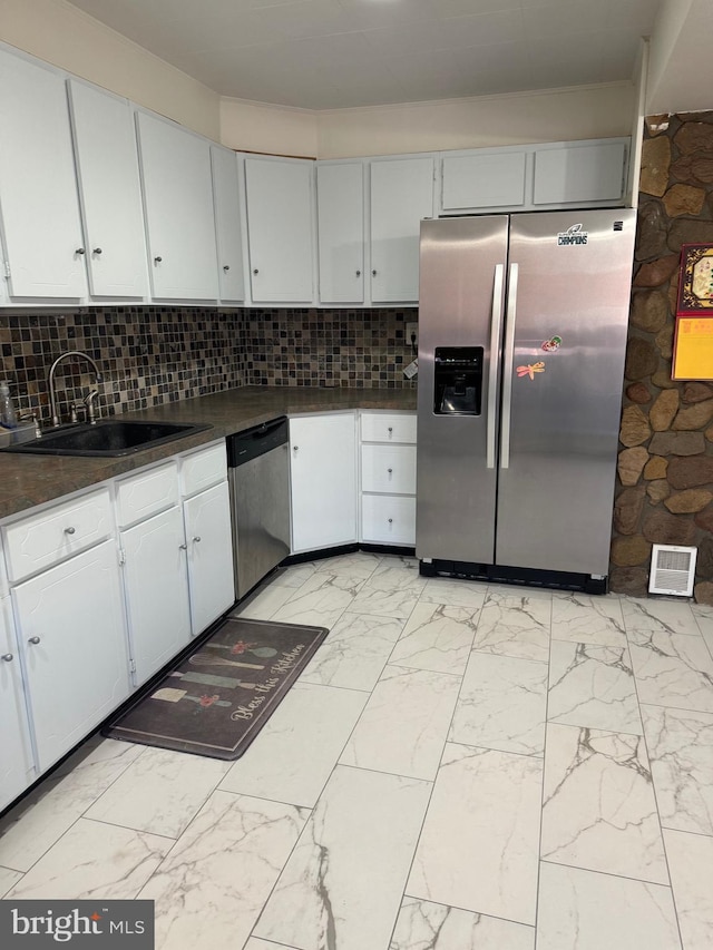 kitchen featuring sink, white cabinets, tasteful backsplash, and appliances with stainless steel finishes