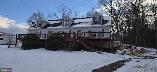 snow covered back of property featuring a wooden deck