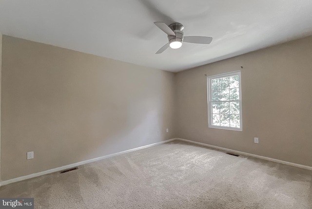 spare room with ceiling fan and carpet