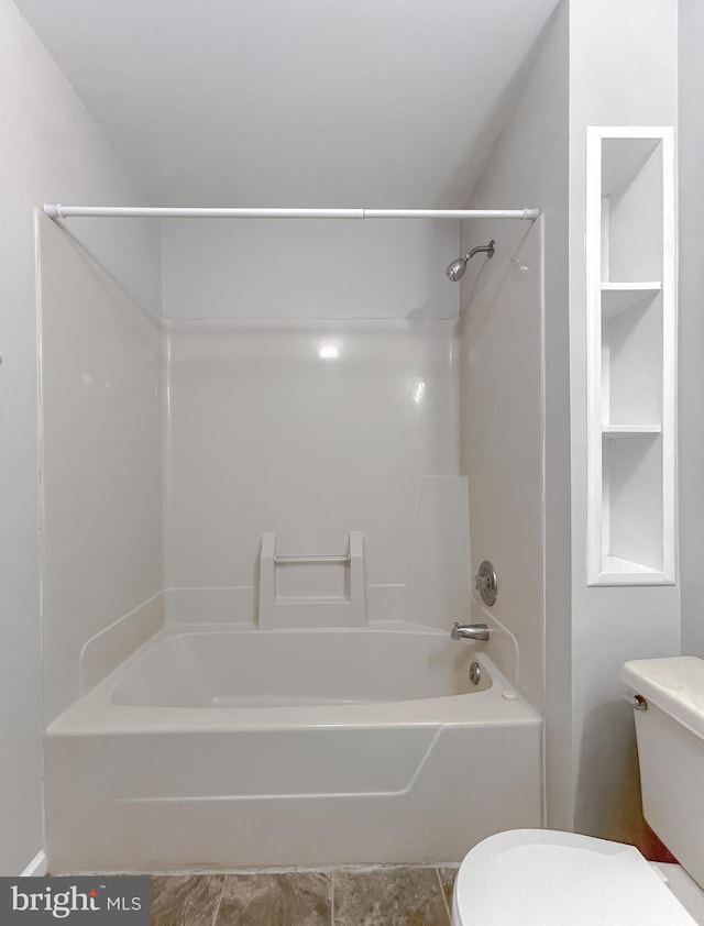 bathroom featuring toilet and  shower combination